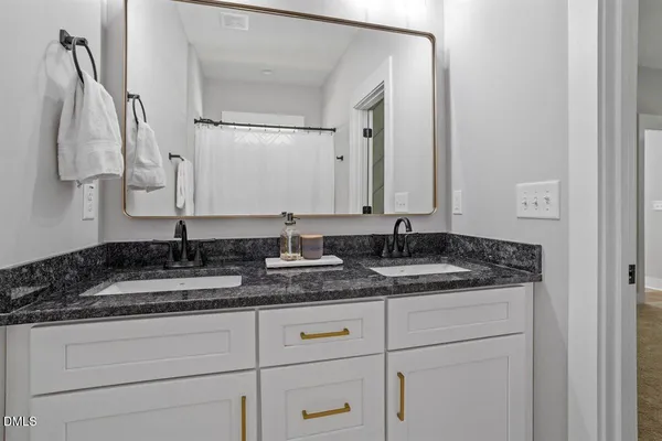 a bathroom with a granite countertop sink and a mirror