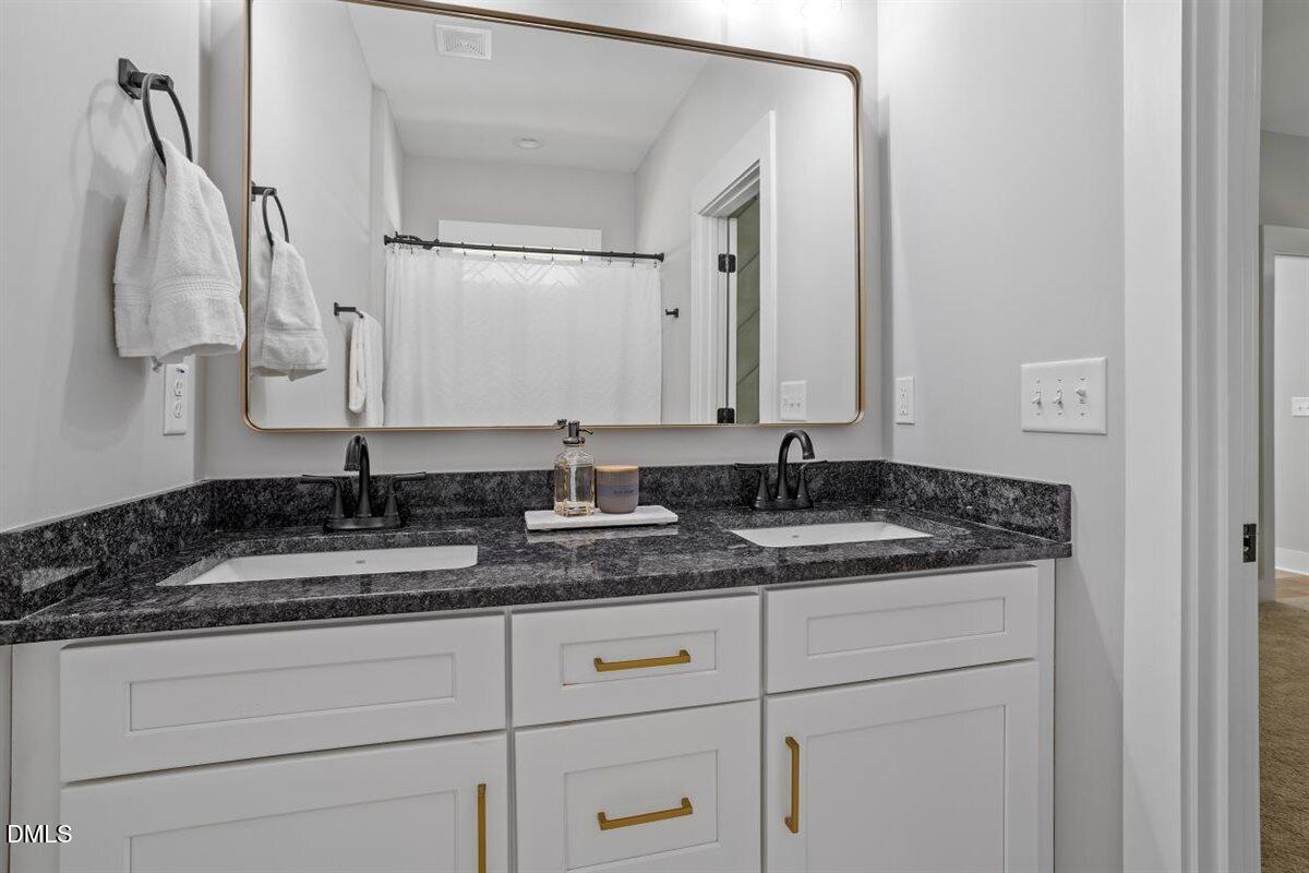 506 Dogwood Road Holly Springs, NC 27540 - Photo 26 of 42 a bathroom with a granite countertop sink and a mirror