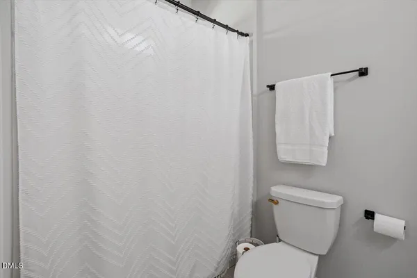 a white toilet sitting next to a shower