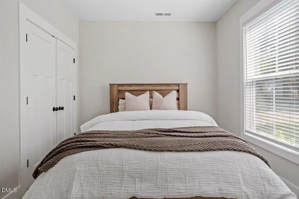 a bedroom with a bed and a window