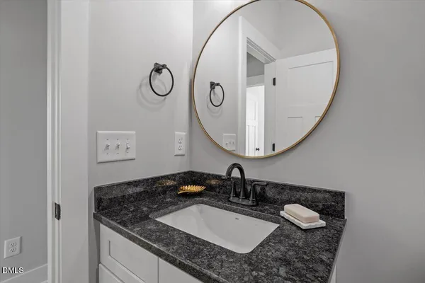 a bathroom with a granite countertop sink and a mirror
