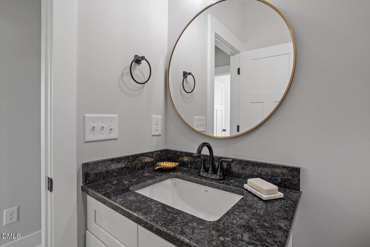 506 Dogwood Road Holly Springs, NC 27540 - Photo 32 of 42 a bathroom with a granite countertop sink and a mirror