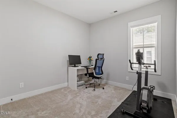 a view of a workspace with furniture and a window