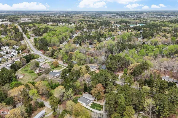 an aerial view of residential houses with outdoor space and trees