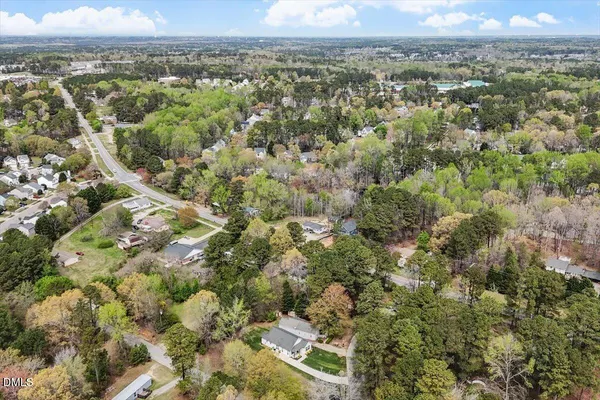 an aerial view of residential houses with outdoor space and trees