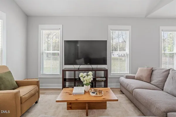 a living room with furniture a flat screen tv and a large window