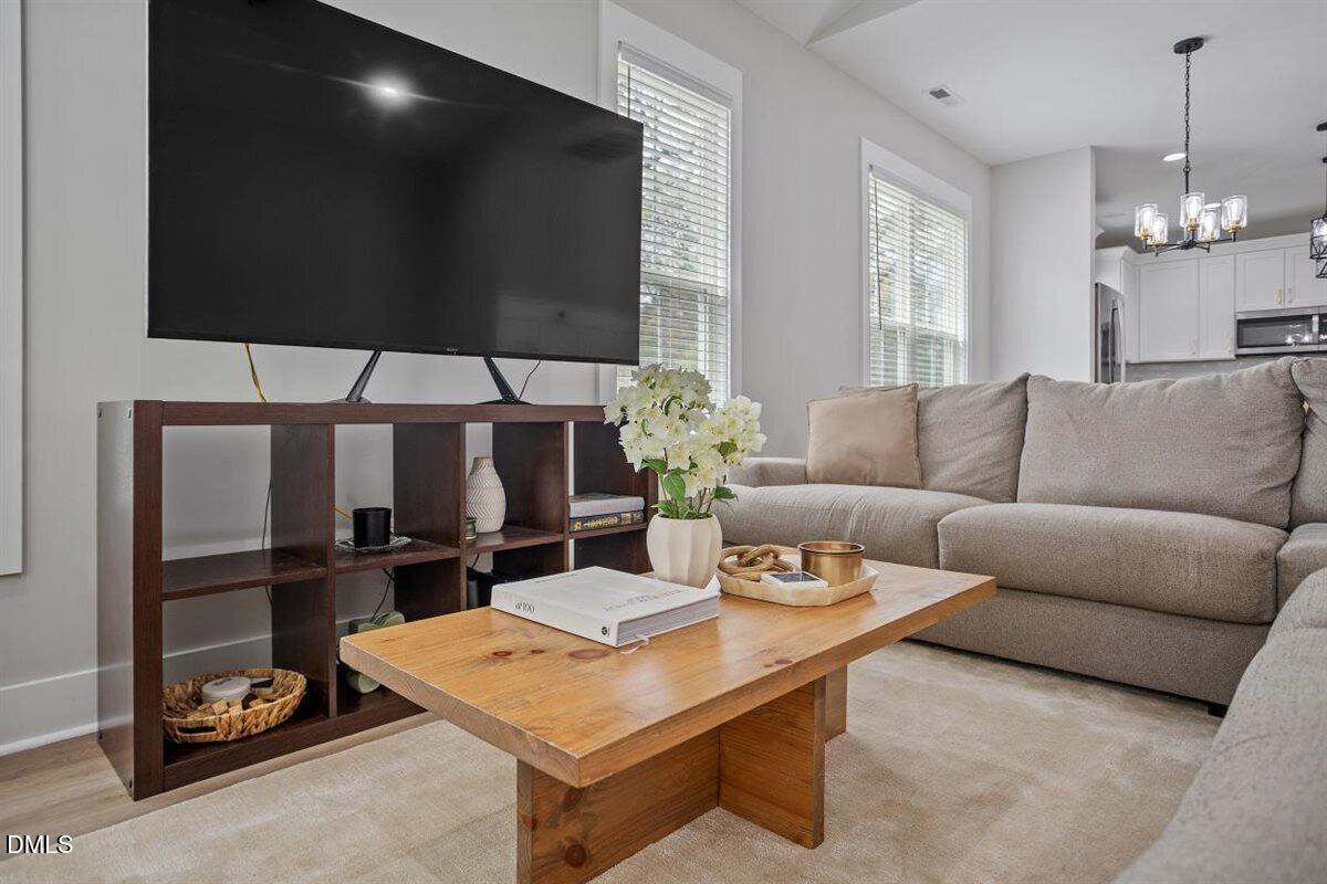 506 Dogwood Road Holly Springs, NC 27540 - Photo 10 of 42 a living room with furniture a flat screen tv and floor to ceiling window
