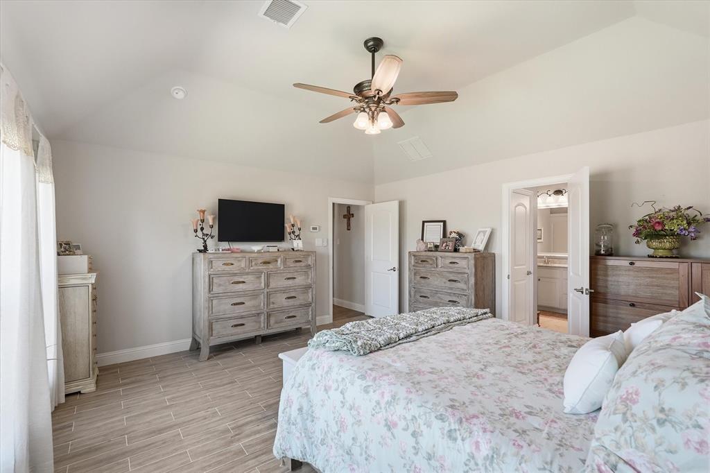 813 Mildren Lane Fate, TX 75087 - Photo 11 of 32 The primary bedroom, with its ensuite bath, is split from the rest of the bedrooms and has plenty of space for multiple pieces of furniture!