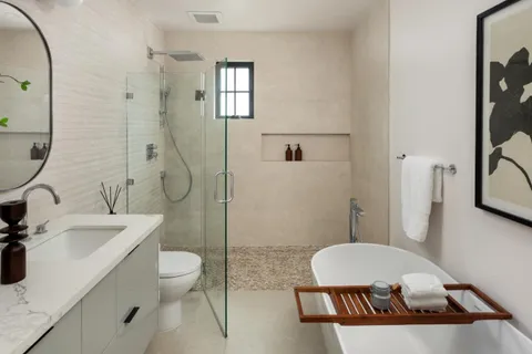 a bathroom with a sink a toilet a mirror and shower