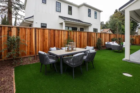 a view of a patio with couches table and chairs and potted plants