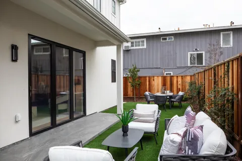 a view of backyard with small cabin and wooden fence