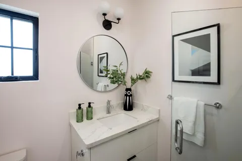a bathroom with a sink mirror and vanity