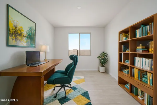 a view of a workspace with furniture and a bookshelf