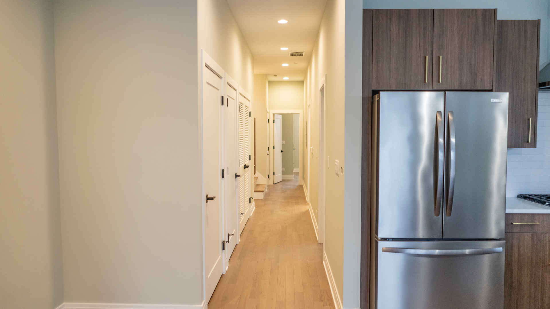 4211 West Roscoe Street, Unit 2W Chicago, IL 60641 - Photo 3 of 12 a view of a refrigerator in kitchen and wooden floor