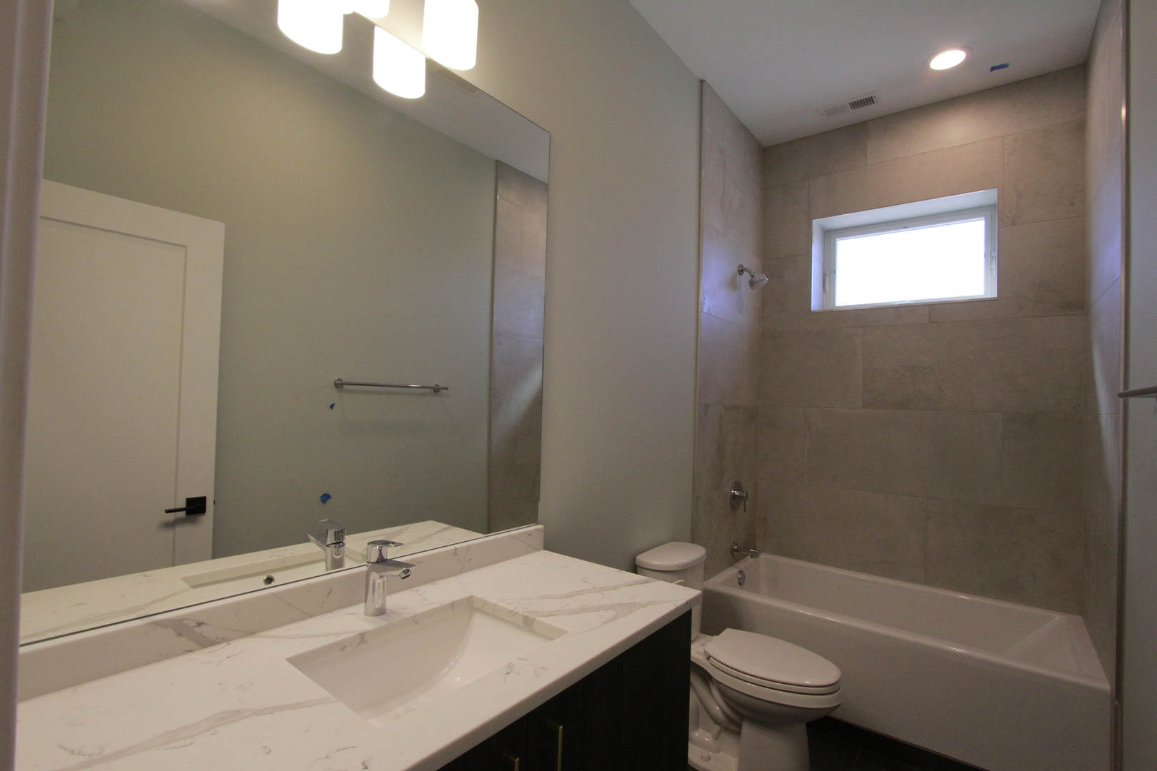 4211 West Roscoe Street, Unit 2W Chicago, IL 60641 - Photo 6 of 12 a bathroom with a sink a toilet and shower