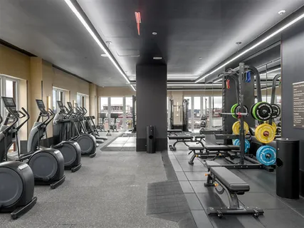 a gym room with gym equipment and a large window