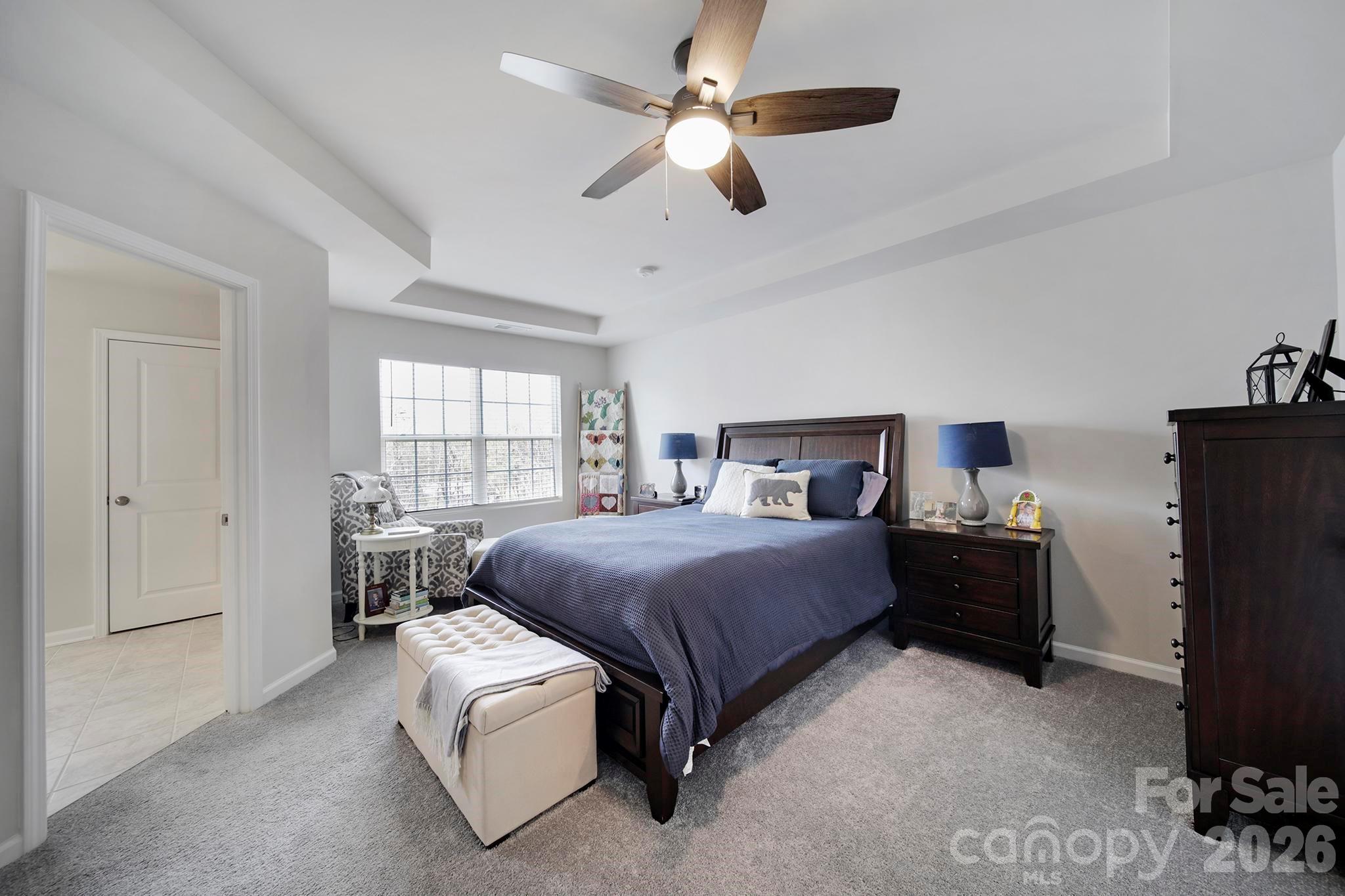 7032 Everly Commons Lane Fort Mill, SC 29708 - Photo 16 of 37 a bedroom with a bed and a chandelier