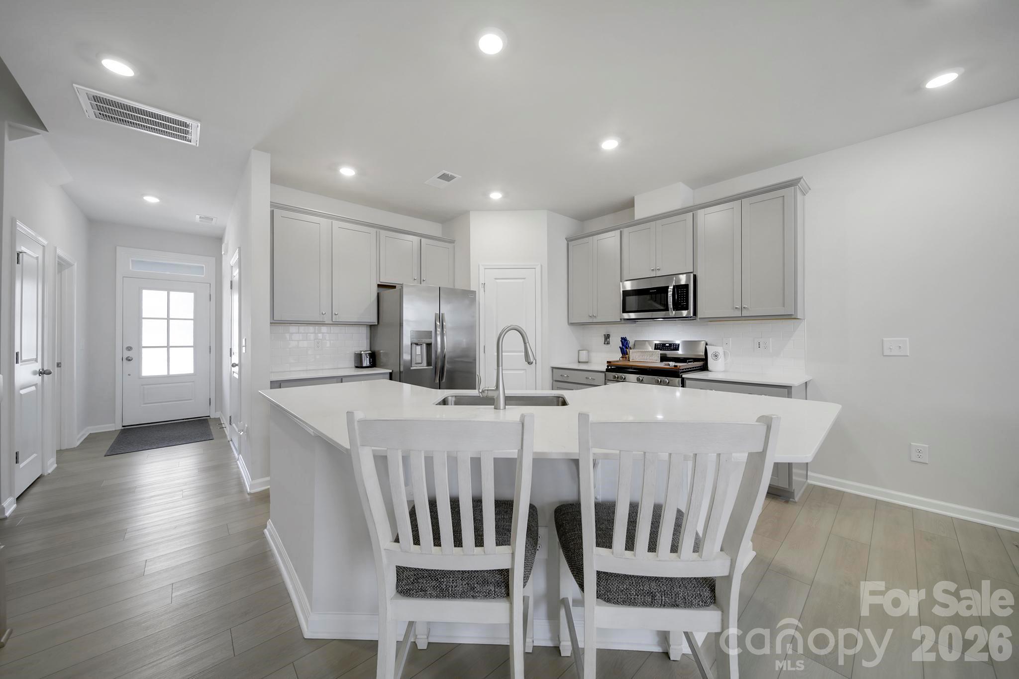 7032 Everly Commons Lane Fort Mill, SC 29708 - Photo 7 of 37 a large kitchen with dining table chairs and refrigerator