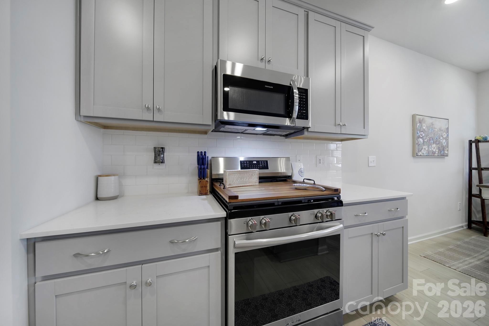 7032 Everly Commons Lane Fort Mill, SC 29708 - Photo 9 of 37 a kitchen with stainless steel appliances granite countertop grey cabinets a stove a sink and dishwasher