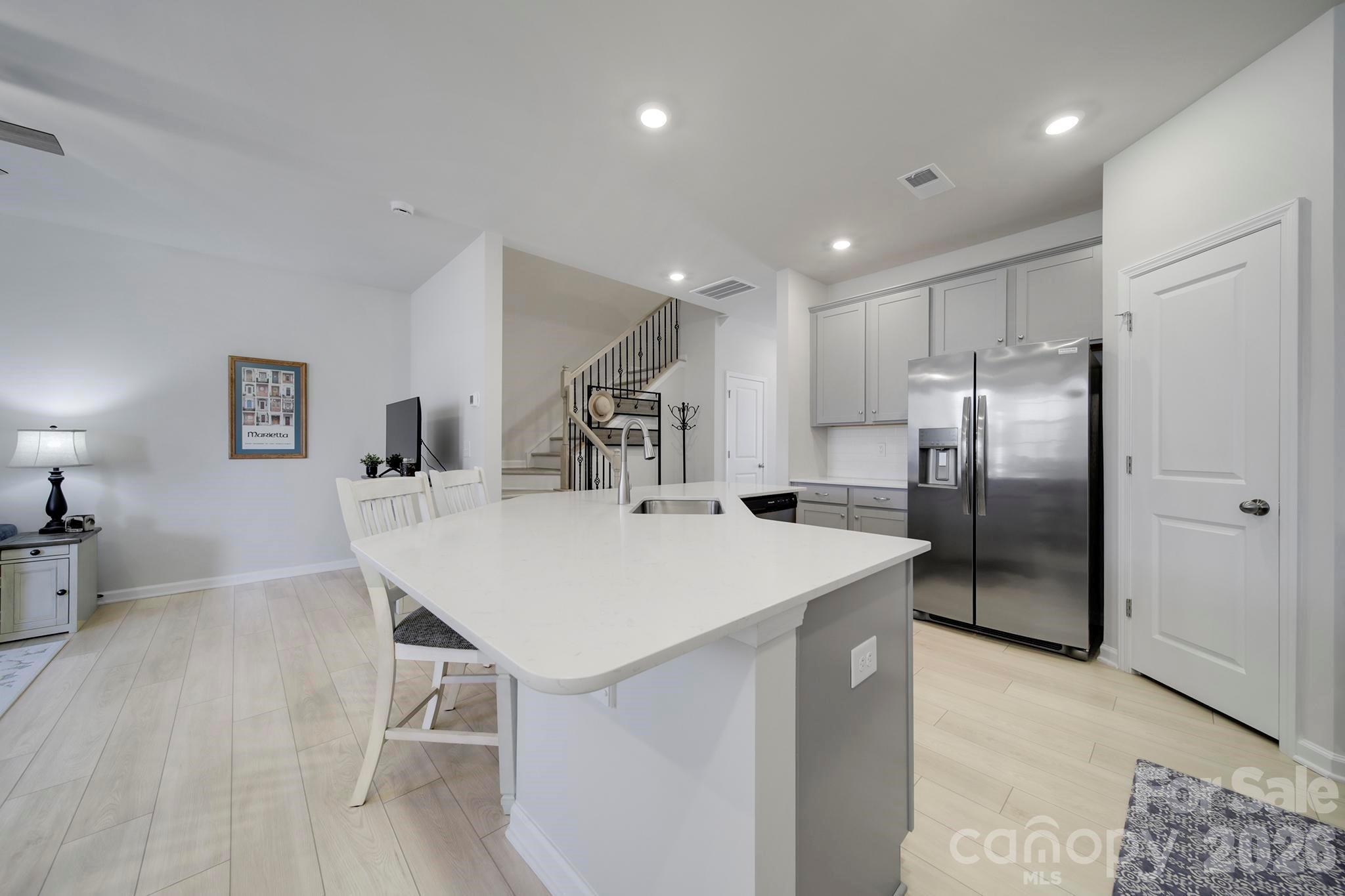 7032 Everly Commons Lane Fort Mill, SC 29708 - Photo 10 of 37 a kitchen with a refrigerator a sink and chairs