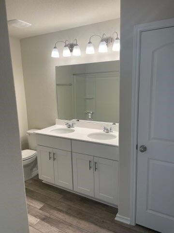 129 Onna Street Taylor, TX 76574 - Photo 8 of 12 a bathroom with a double vanity sink mirror and toilet