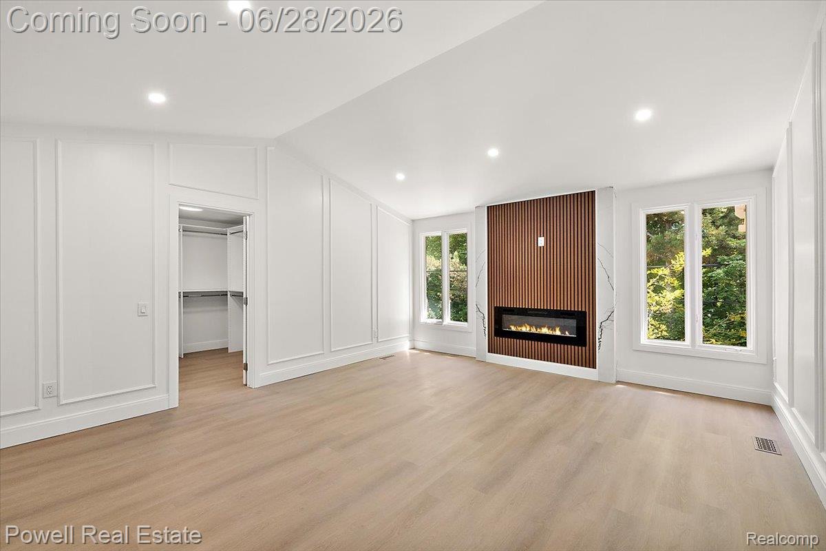 1447 Ravineview Court, Unit C12 Bloomfield Hills, MI 48304 - Photo 31 of 49 Spacious room featuring a modern linear electric fireplace with a slatted wood accent wall and stone-look surround