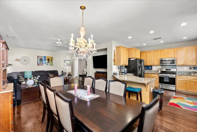 a view of a dining room and livingroom with furniture wooden floor a chandelier