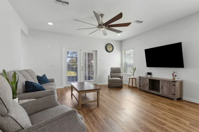 a living room with furniture and a wooden floor