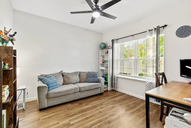 a view of a livingroom with wooden floor and furniture