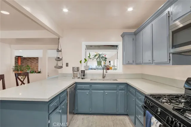 a kitchen with a sink a stove and cabinets