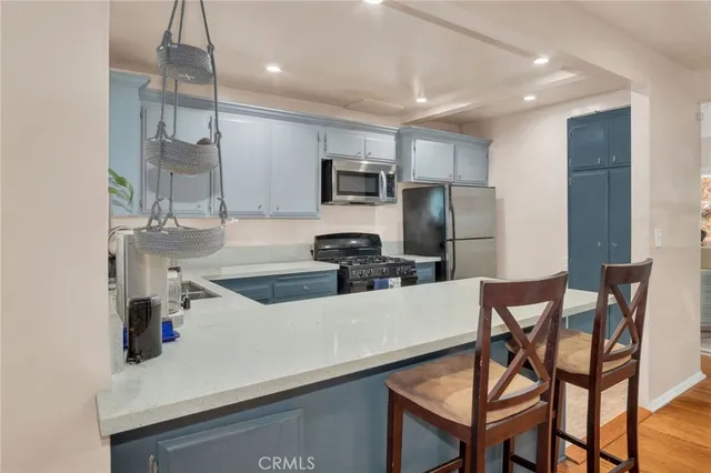 a kitchen with kitchen island a refrigerator stove and microwave