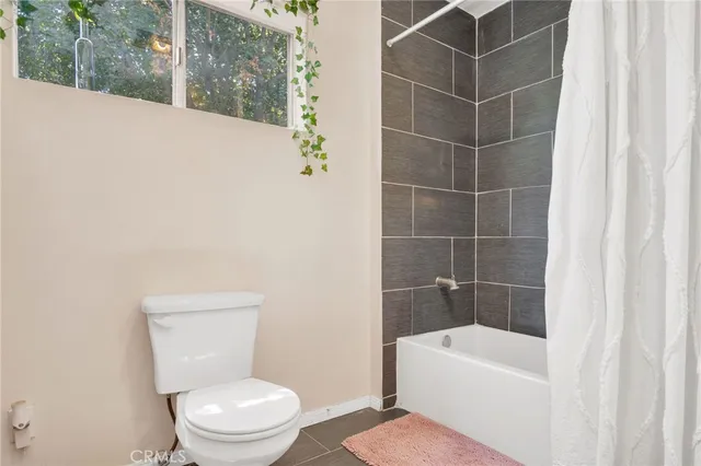 a white toilet sitting next to a white bath tub