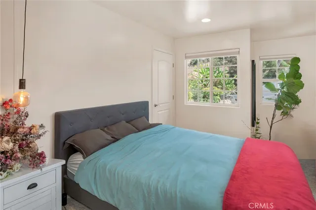 a bed sitting in a bedroom next to a window