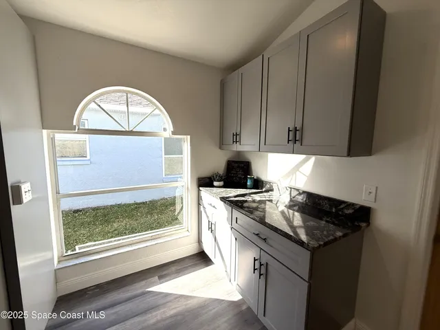 a bathroom with a granite countertop sink toilet and mirror