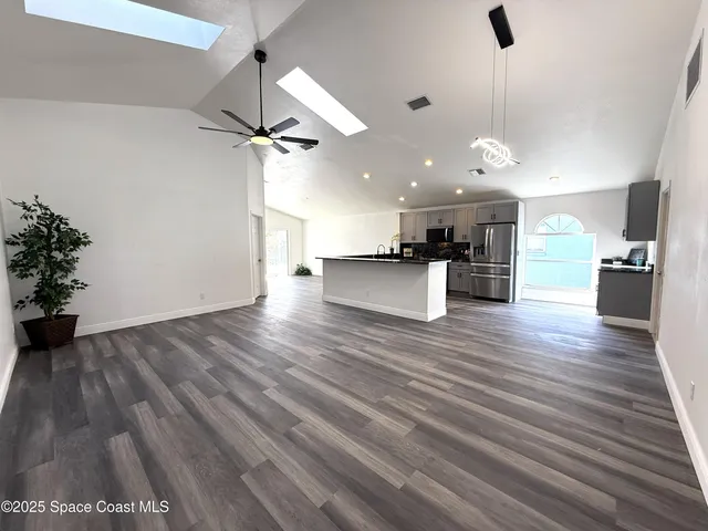 a white kitchen with granite countertop stainless steel appliances