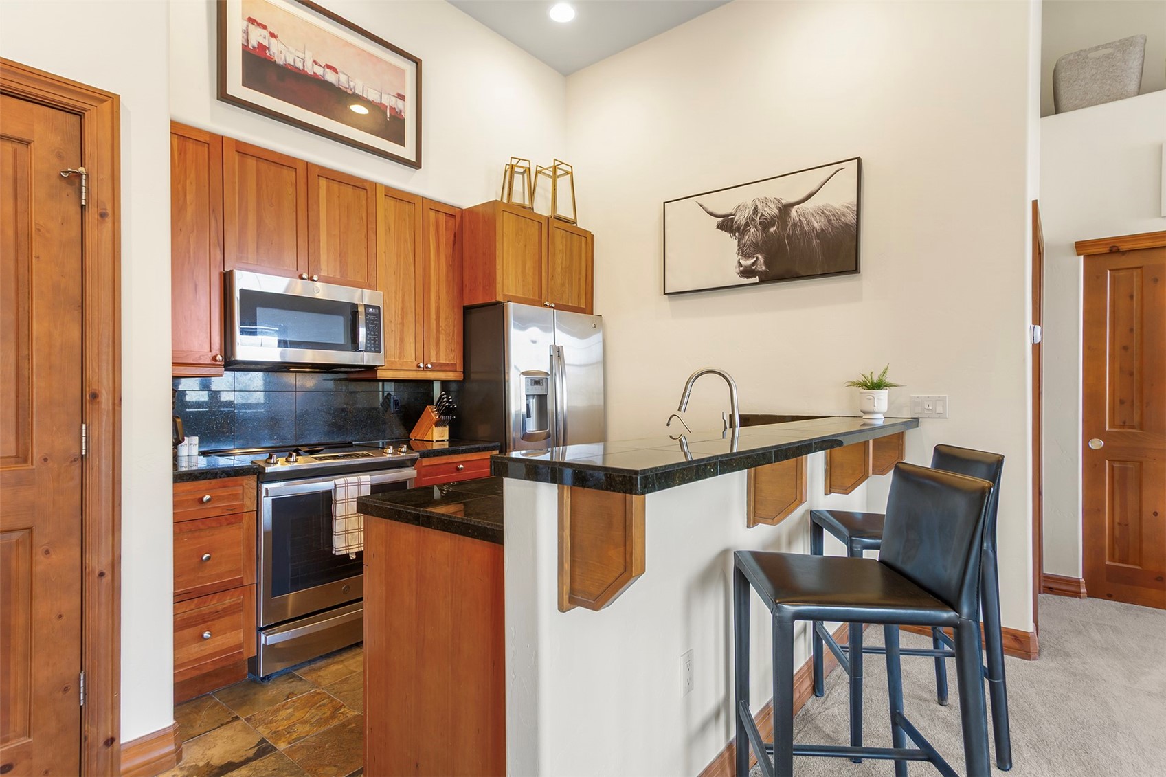 34 Highfield Trail, Unit 404 Breckenridge, CO 80424 - Photo 8 of 25 a kitchen with stainless steel appliances granite countertop a stove top oven a sink a dining table and chairs with wooden floor
