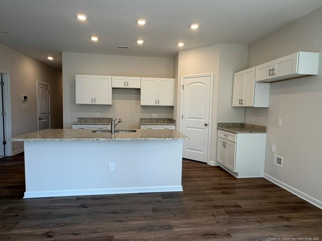 5409 Short Leaf Road Fayetteville, NC 28311 - Photo 16 of 40 a large kitchen with stainless steel appliances granite countertop a stove a sink and white cabinets