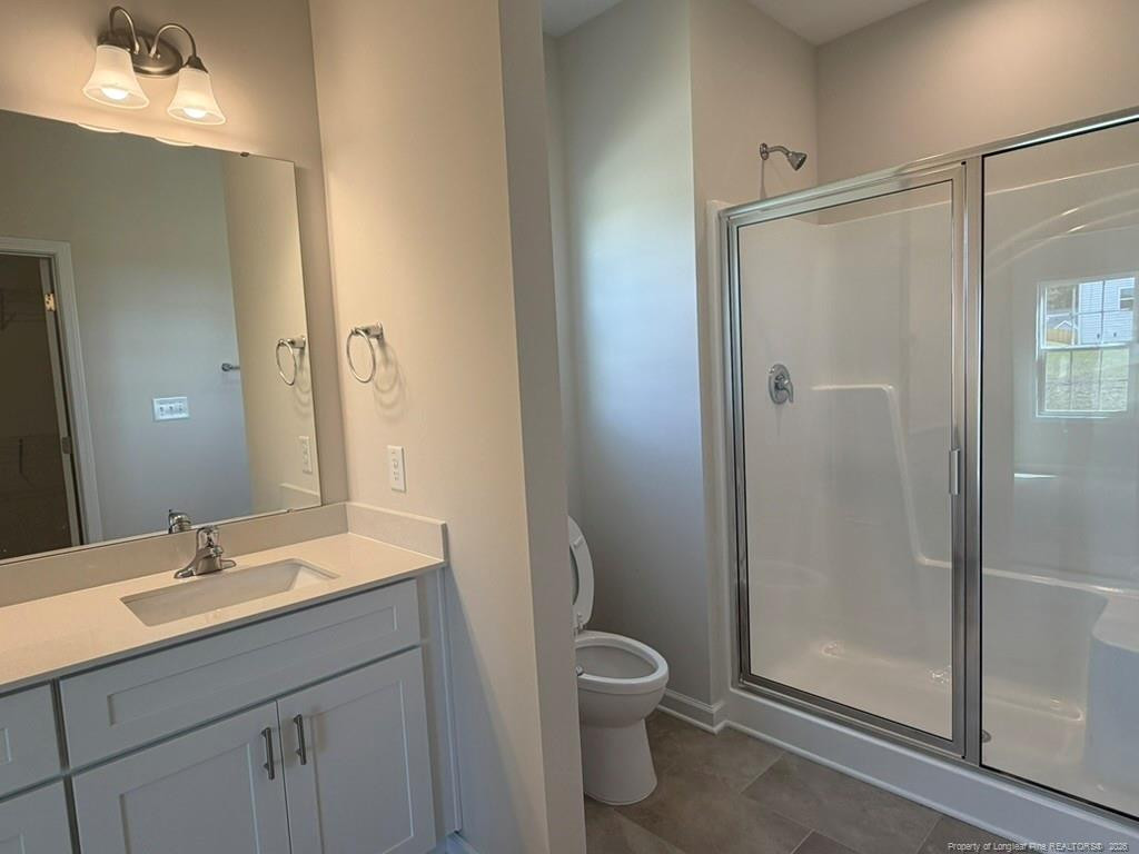 5409 Short Leaf Road Fayetteville, NC 28311 - Photo 30 of 40 a bathroom with a shower sink vanity and a toilet