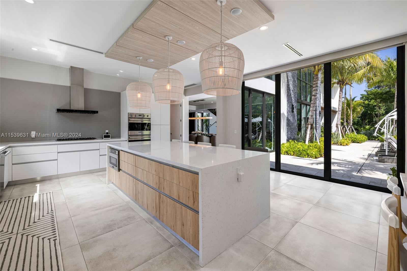 5840 Moss Ranch Road Pinecrest, FL 33156 - Photo 23 of 83 a large white kitchen with a large window and stainless steel appliances