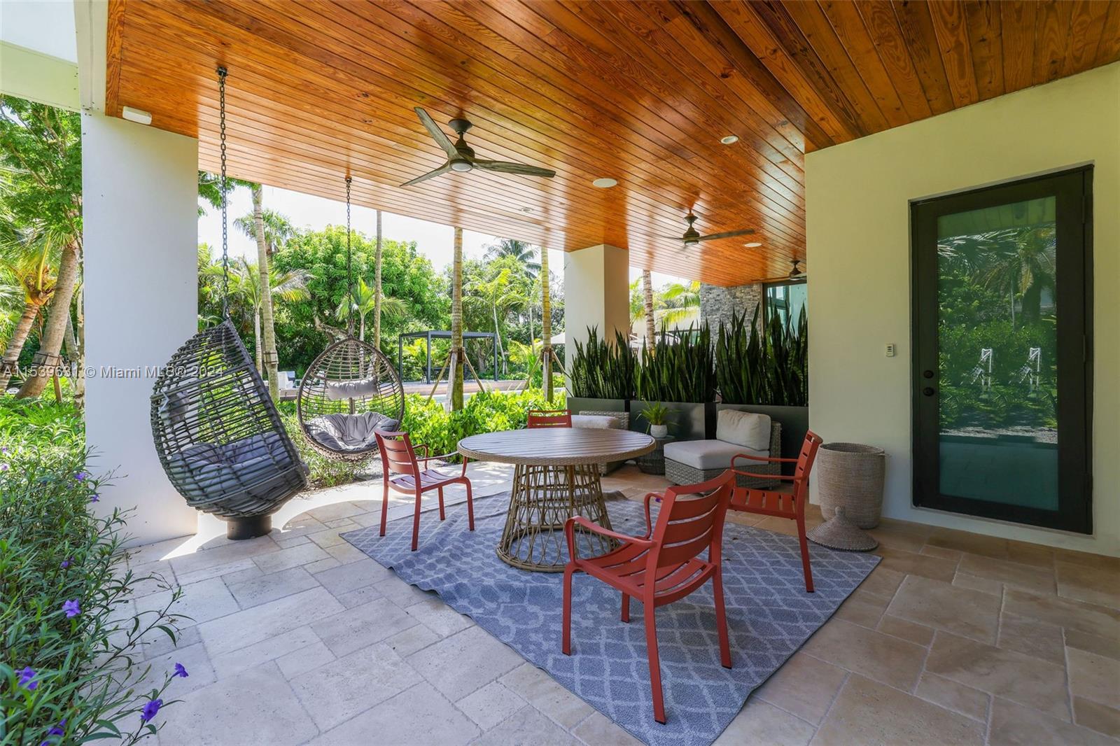 5840 Moss Ranch Road Pinecrest, FL 33156 - Photo 48 of 83 a view of a patio with a table chairs and a potted plant