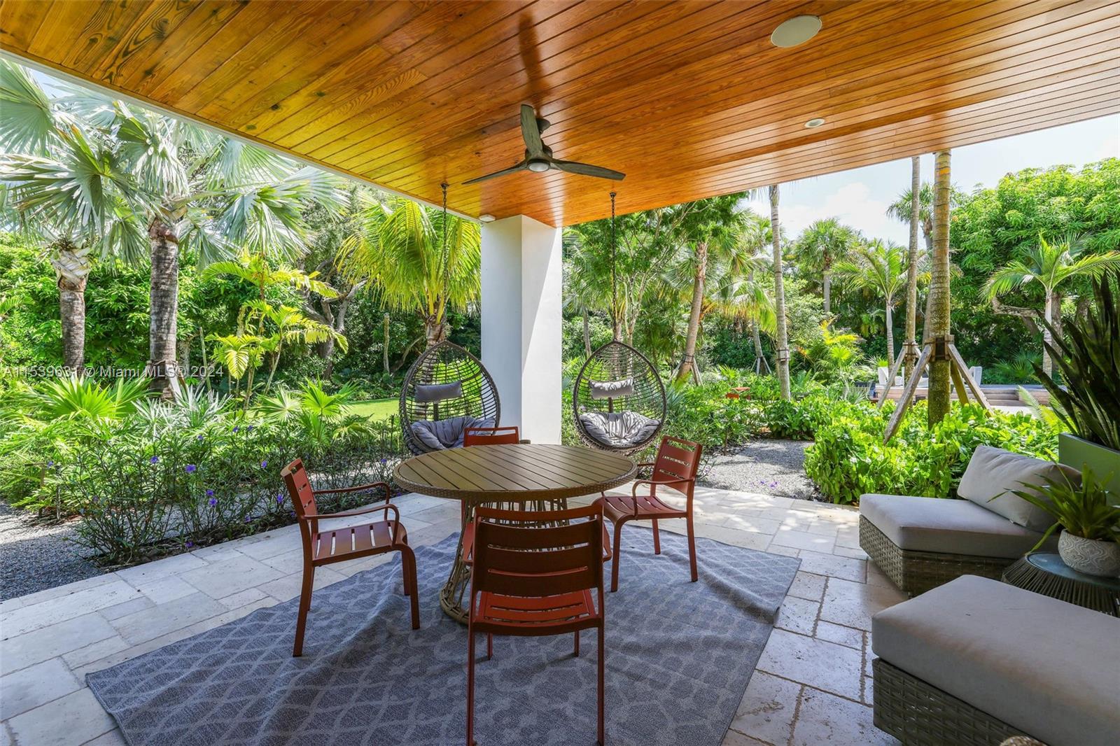 5840 Moss Ranch Road Pinecrest, FL 33156 - Photo 49 of 83 a view of a patio with table and chairs and potted plants