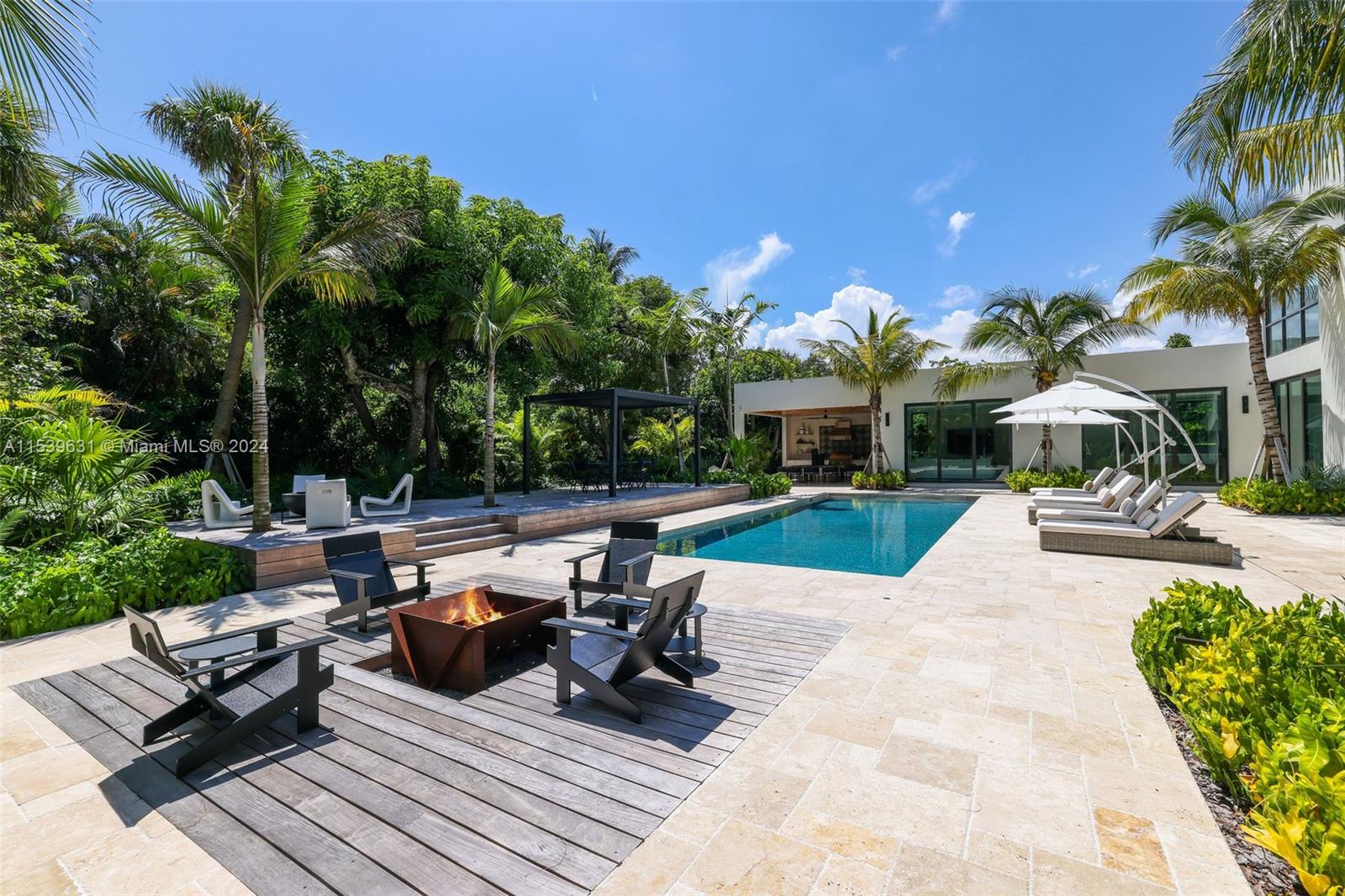 5840 Moss Ranch Road Pinecrest, FL 33156 - Photo 67 of 83 a view of a patio with couches table and chairs with plants and palm trees