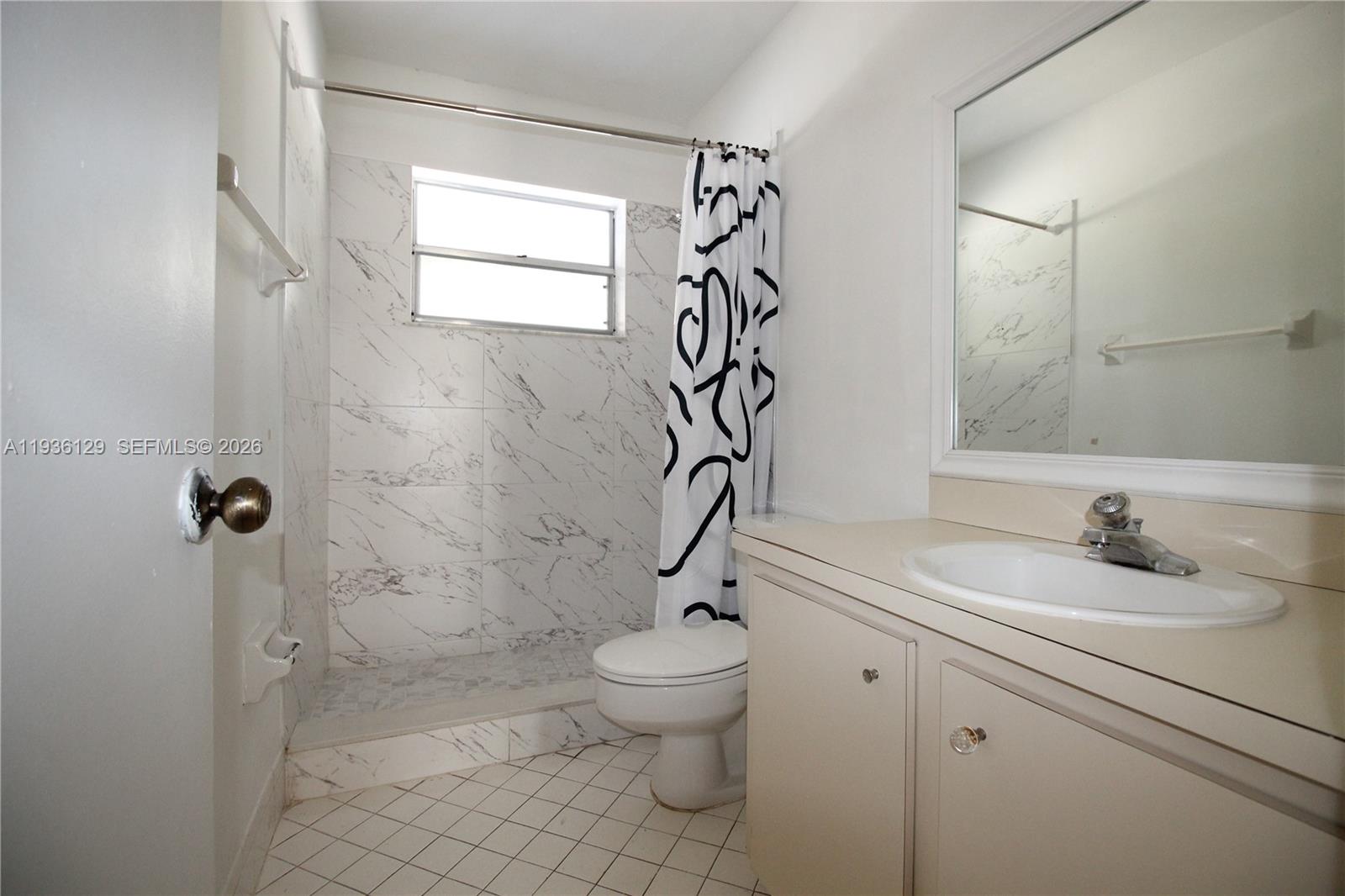 8990 West Sample Road, Unit 206 Coral Springs, FL 33065 - Photo 13 of 28 a bathroom with a sink a toilet and shower