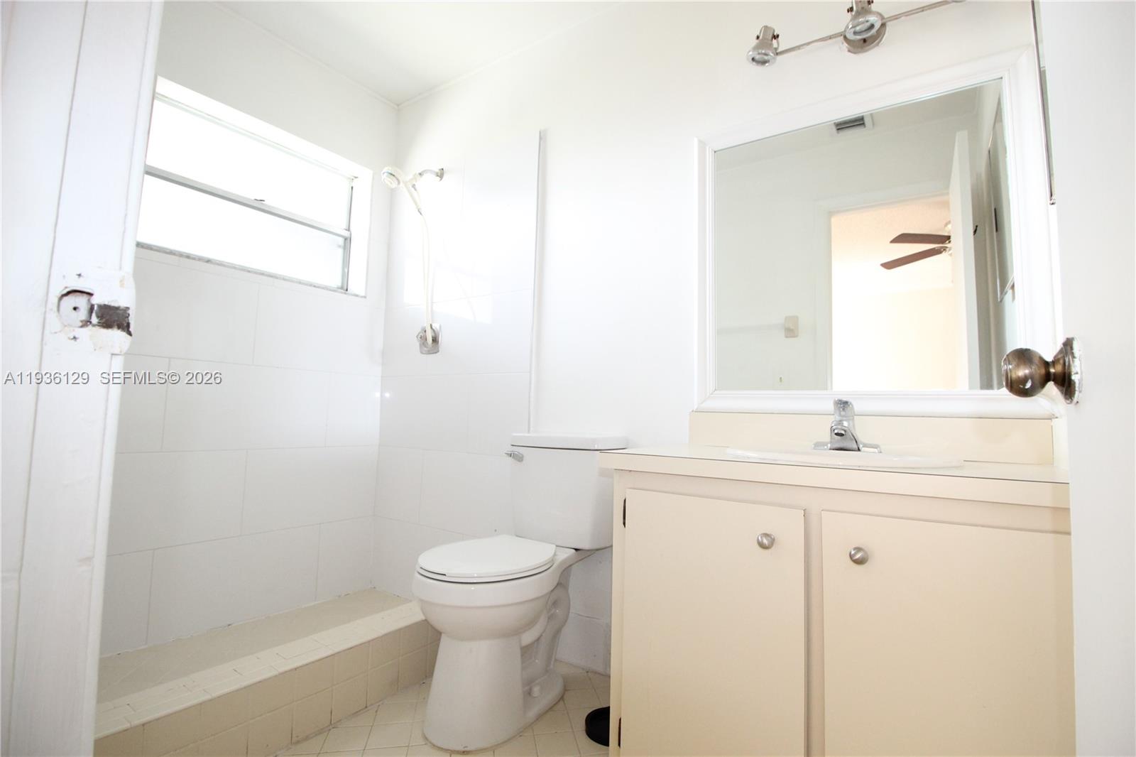 8990 West Sample Road, Unit 206 Coral Springs, FL 33065 - Photo 20 of 28 a bathroom with a granite countertop sink toilet and shower