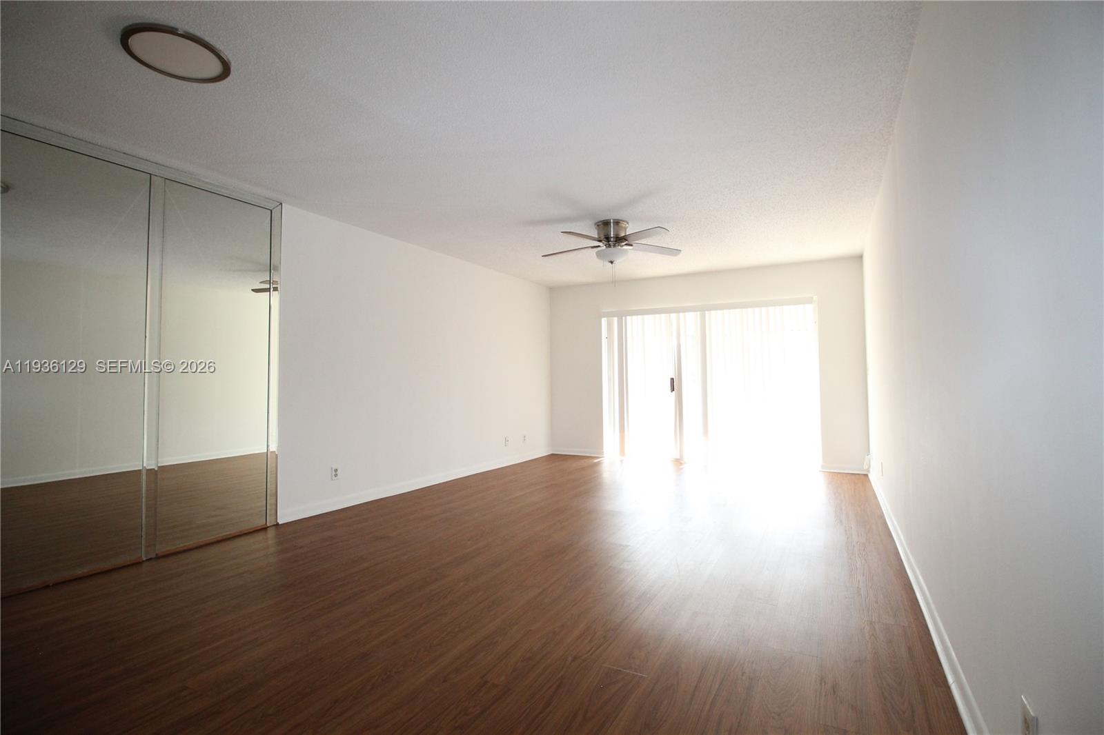 8990 West Sample Road, Unit 206 Coral Springs, FL 33065 - Photo 7 of 28 an empty room with wooden floor and windows