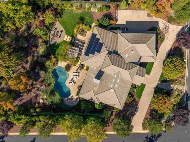 an aerial view of a house with a yard and lake view