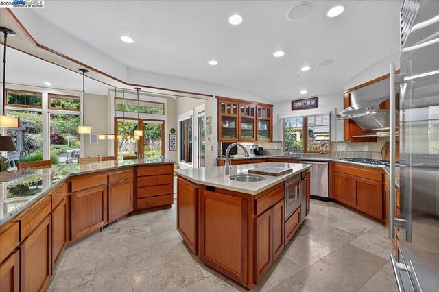 a kitchen with stainless steel appliances granite countertop a sink and a stove