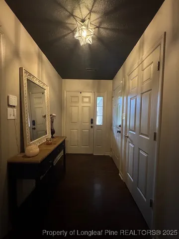 a view of a hallway with a dining table & chairs