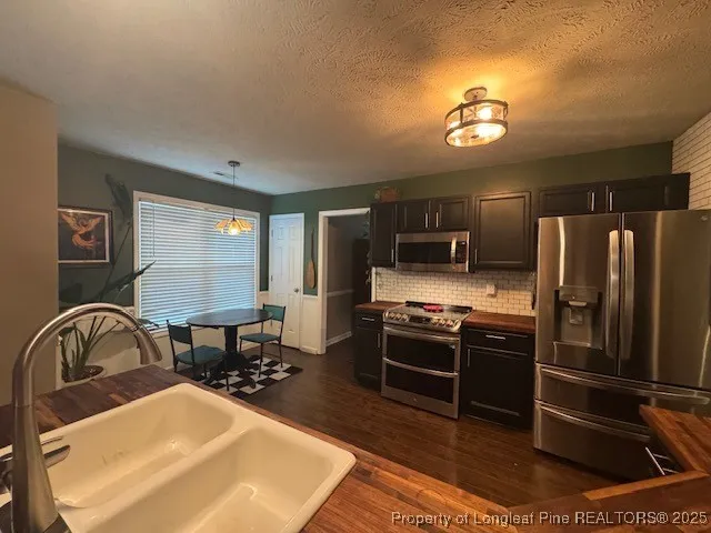a kitchen with stainless steel appliances granite countertop a sink a stove and a refrigerator