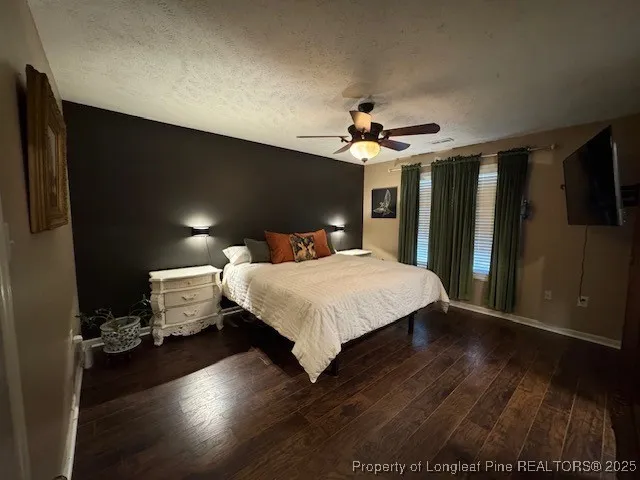 a large bedroom with a bed and wooden floor